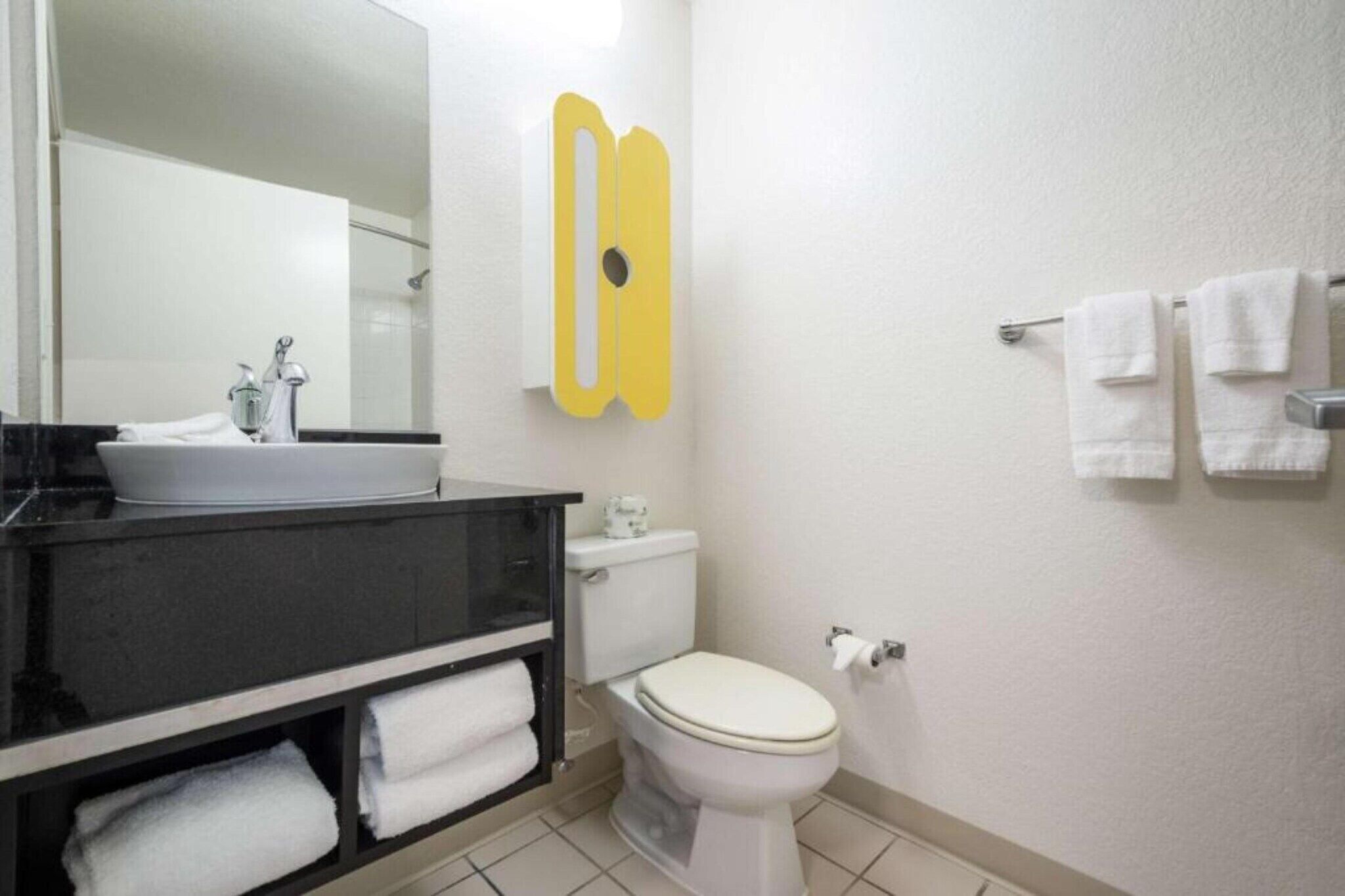A bathroom with a white sink, toilet, and towel rack.