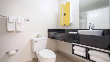 A modern bathroom with a toilet, sink, and mirror.