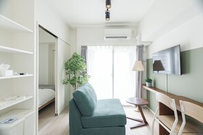A hotel room with a bed, a sofa, a TV, a desk, and a plant. - Premiage Minoshima (Hakata Ward, Fukuoka)