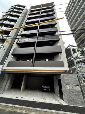 A multi-story building with a modern architectural design, featuring balconies and a covered entrance. - Premiage Minoshima (Hakata Ward, Fukuoka)