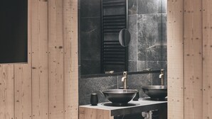 Une salle de bain moderne avec des murs en bois, un grand miroir et un lavabo intégré.