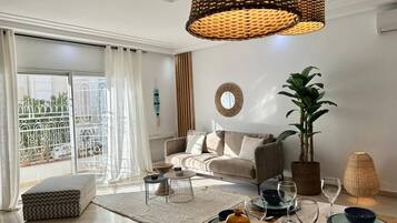 A modern living room with a sofa, coffee table, and dining area set.