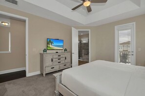 A bedroom with a bed, a dresser, a television, and a ceiling fan. - Private Pool and Spa/10 Mins Disney/Ping Pong/Onsite Bar with views to Fireworks (Kissimmee)
