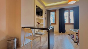 A compact living space with a kitchenette, a dining area, and a small table with chairs. - Taksim Square—1BR Suite 01 (Beyoğlu)