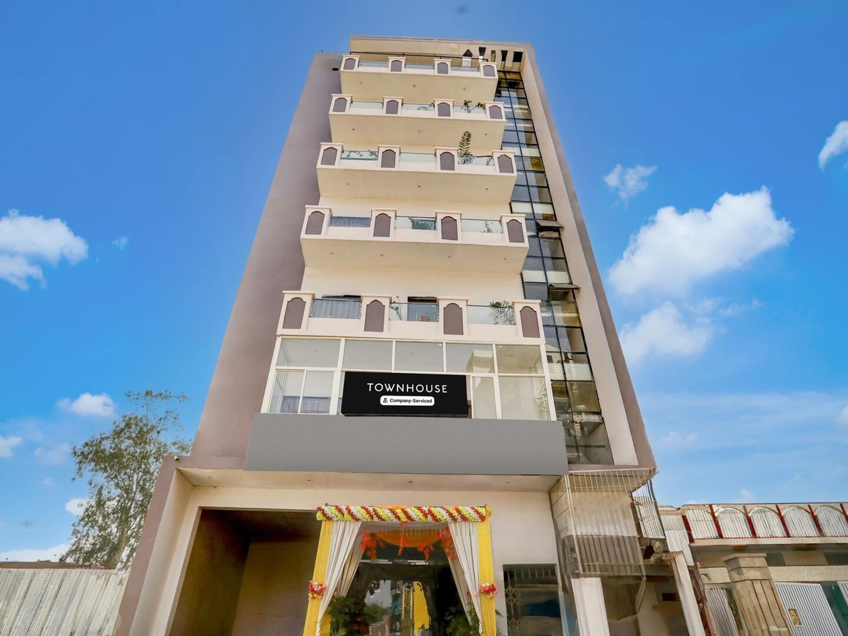 A multi-story building with a sign reading 'TOWNHOUSE' and balconies.