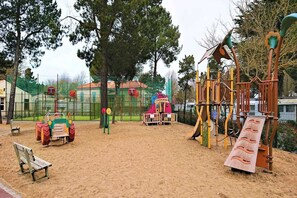 A playground with various play structures, a sandbox, and a bench. - 3-bedroom holiday home in Loire (Saint-Jean-de-Monts)