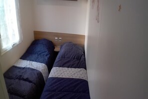 A small room with two single beds, a window, and a wall-mounted light switch. - 3-bedroom holiday home in Loire (Saint-Jean-de-Monts)