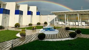 Un edificio con una fuente, una estatua y un camino a cuadros.