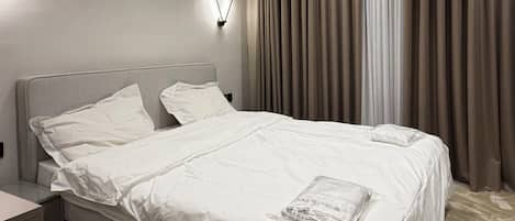 Tabla de planchar con plancha, internet y ropa de cama