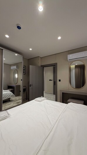 Ein Hotelzimmer mit Bett, Spiegel, Klimaanlage und einer Tür.