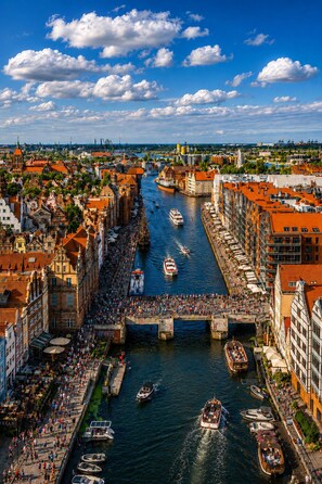 Une rivière où l’on peut voir des bateaux, un pont et des bâtiments le long des rives.