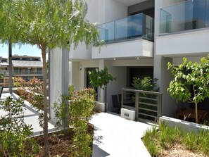 A modern building with a balcony, outdoor seating, and greenery. - Two Bedroom Suite Tatiana in Nikiti (Nikiti city)