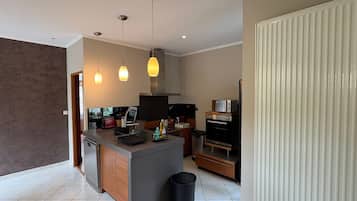 A modern kitchen with a central island, built-in oven, and pendant lighting.