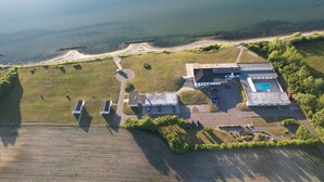 An aerial view of a property with a swimming pool, a large building, and a surrounding grassy area. - Sct. Knudsborg - Cottages (Middelfart)