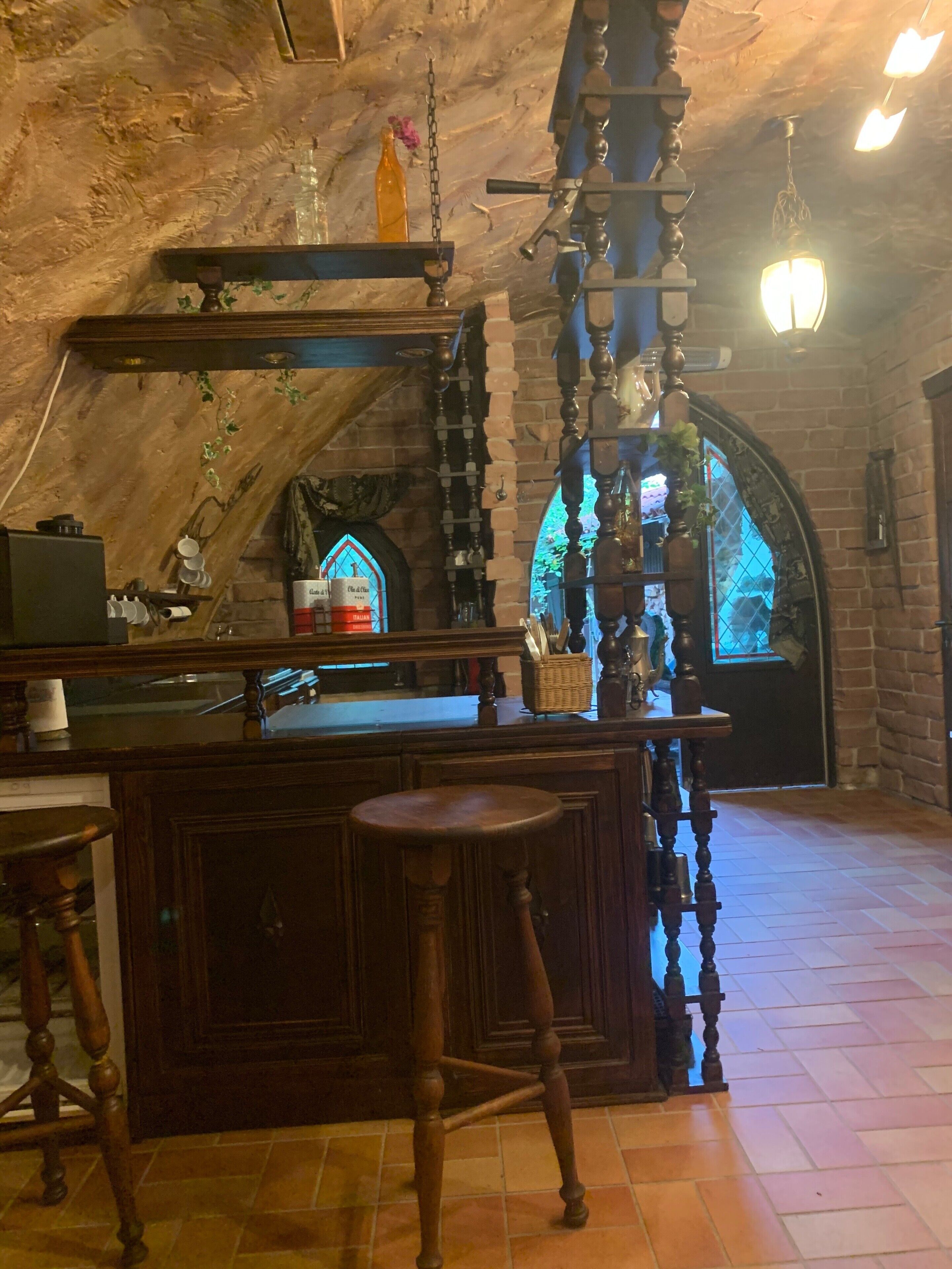 Ein rustikales Interieur mit einer Holztheke, einer Steinwand und einer hängenden Leuchte.