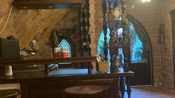 Ein rustikales Interieur mit einer Holztheke, einer Steinwand und einer hängenden Leuchte.