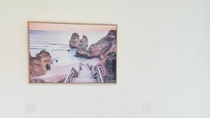 Un divano marrone con una ciotola nera su un tavolo di legno in una stanza con un quadro appeso al muro.