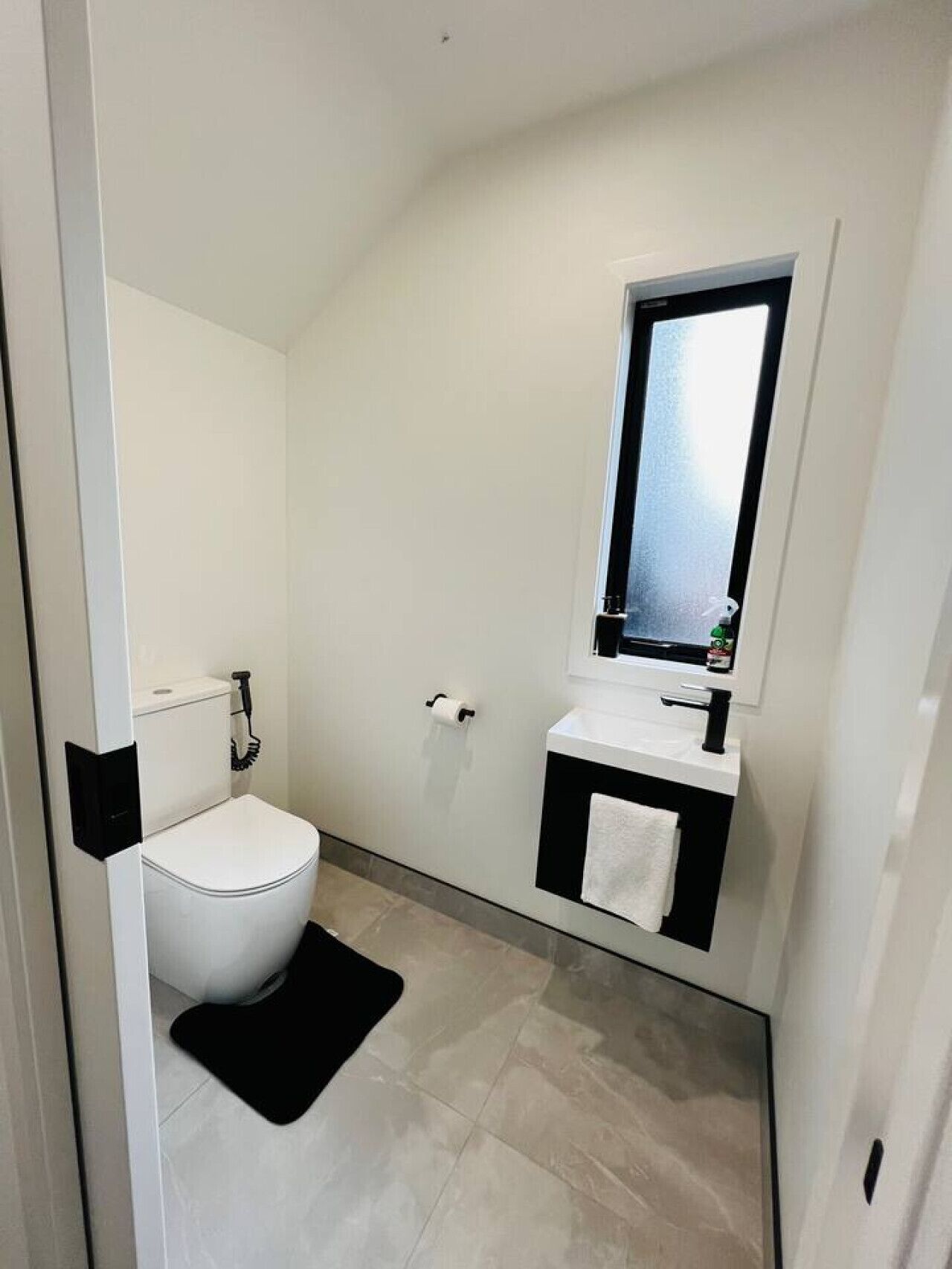 Moderni kylpyhuone, jossa on wc, pesuallas ja peili.