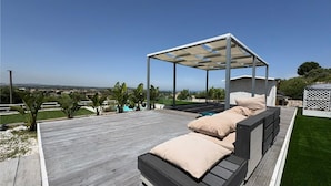 A wooden deck with a covered seating area and a view of the landscape. - Rari House by Geco Vacation Rentals (Brucoli)