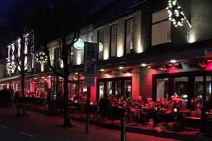 Ein Gebäude mit beleuchteten Schildern und einem Restaurant mit Außenbereich.