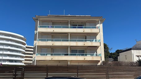Un edificio de varios pisos con balcones, techo plano y un cielo azul despejado.. Apartamento 'Brisas Del Mar Pb-3' con piscina comunitaria, Wi-Fi y aire acondicionado