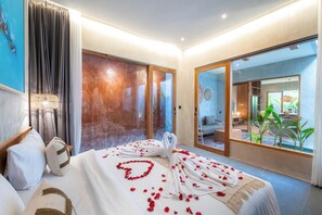 Een hotelkamer met een bed, gordijnen, een lamp en uitzicht.