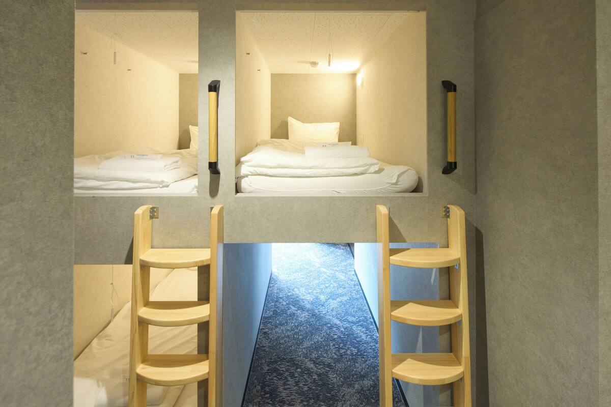 A room with two beds, each with a headboard and a wooden ladder.