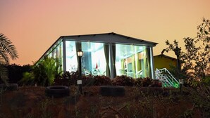 A modern house with a glass facade, a staircase, and outdoor seating. - Bellajooz Lake Resort (Mawal)