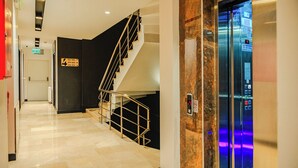 A modern hotel lobby with a marble floor, a staircase, and an elevator. - Haveria Suite Hotel (Istanbul)