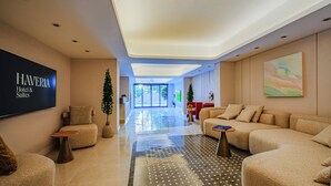 A modern hotel lobby with sofas, a flat-screen TV, and a large painting. - Haveria Suite Hotel (Istanbul)