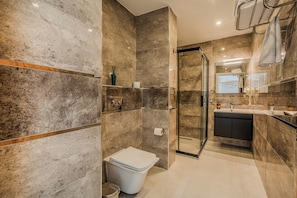 Ein modernes Badezimmer mit Glasdusche, Toilette und Waschbecken mit Waschtisch.