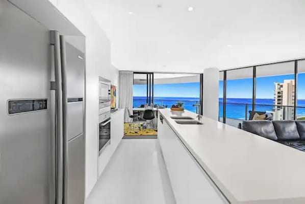 Eine moderne Küche mit Meerblick, einem Essbereich und einem Wohnbereich mit einer Couch.
