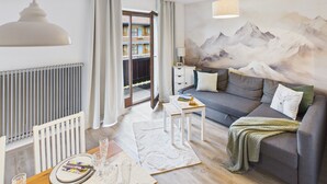 A modern living room with a sofa, a coffee table, a lamp, a radiator, and a view of a balcony. - Vacation apartment Hüttenzauber for 4 persons, 54 m² (Inzell)