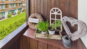 A wooden balcony with a wicker wreath, a heart-shaped decoration, and a watering can. - Vacation apartment Hüttenzauber for 4 persons, 54 m² (Inzell)