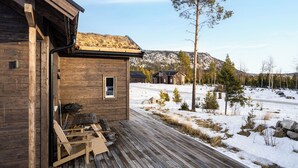 A wooden cabin with a deck, a small window, and a view of a snowy landscape. - Orrmötesvägen 21 - Funäsdalen (Funäsdalen)