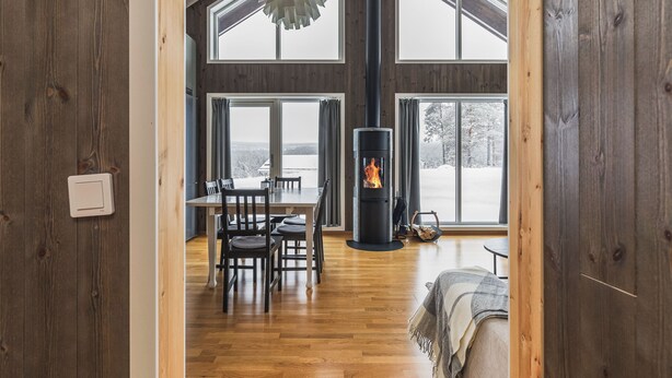 A high-ceilinged room with a fireplace, wooden floors, and large windows. - Orrmötesvägen 21 - Funäsdalen (Funäsdalen)