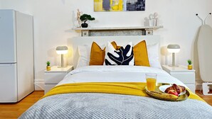 A modern bedroom with a bed, bedside tables, a nightstand, a wall-mounted shelf with decorative items, and a mounted artwork. - Modern Retreat in Birmingham (Birmingham)