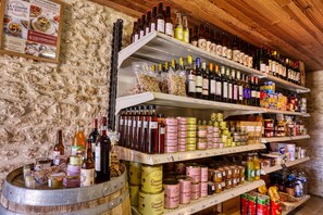 A wine cellar with shelves of wine bottles and canned goods. - Cottage near Sarlat, ideal for couples or families. Pets are welcome. (Proissans)