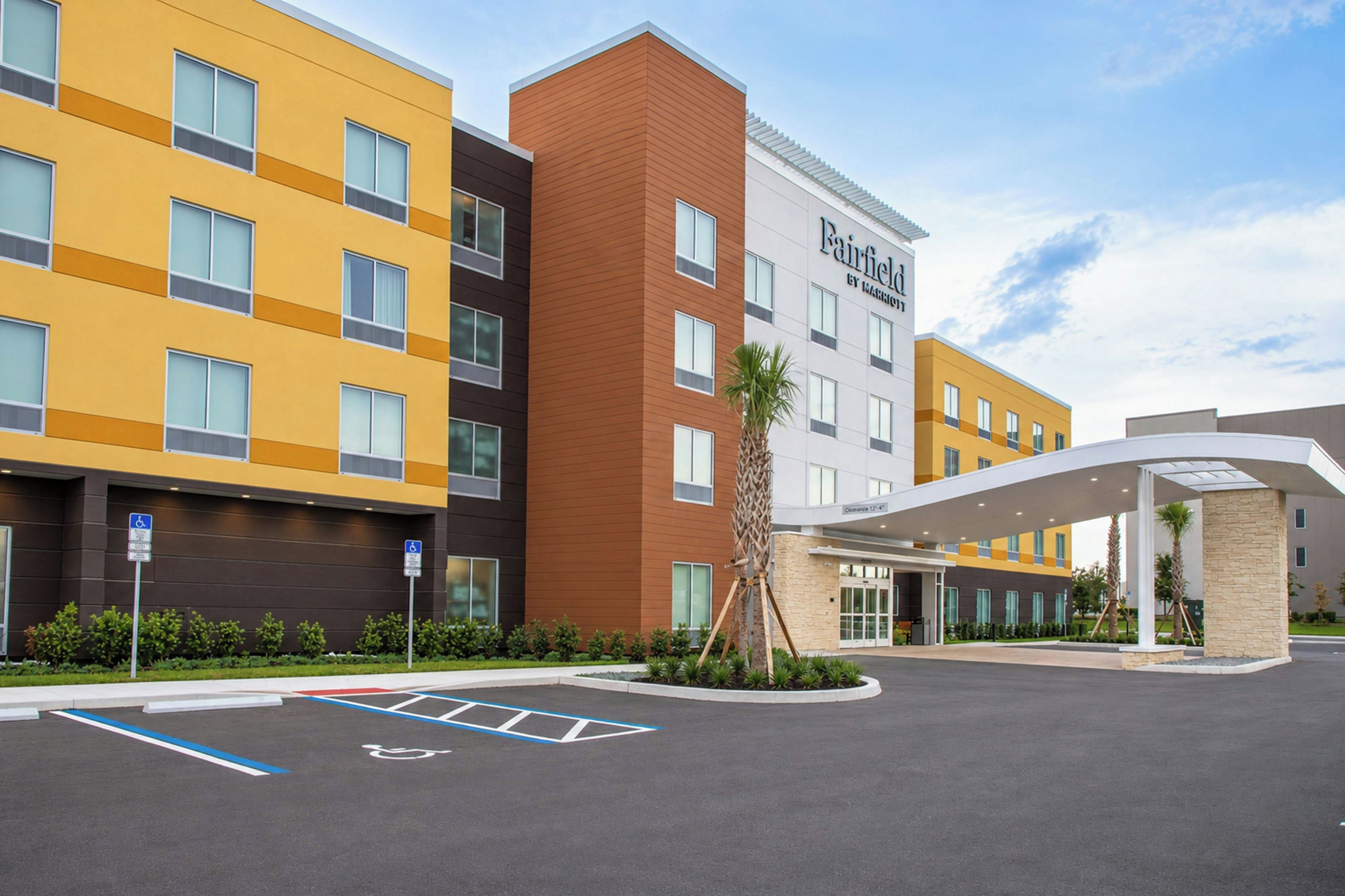 A hotel with multiple buildings, a parking lot with handicapped accessible spaces, and a covered entrance.