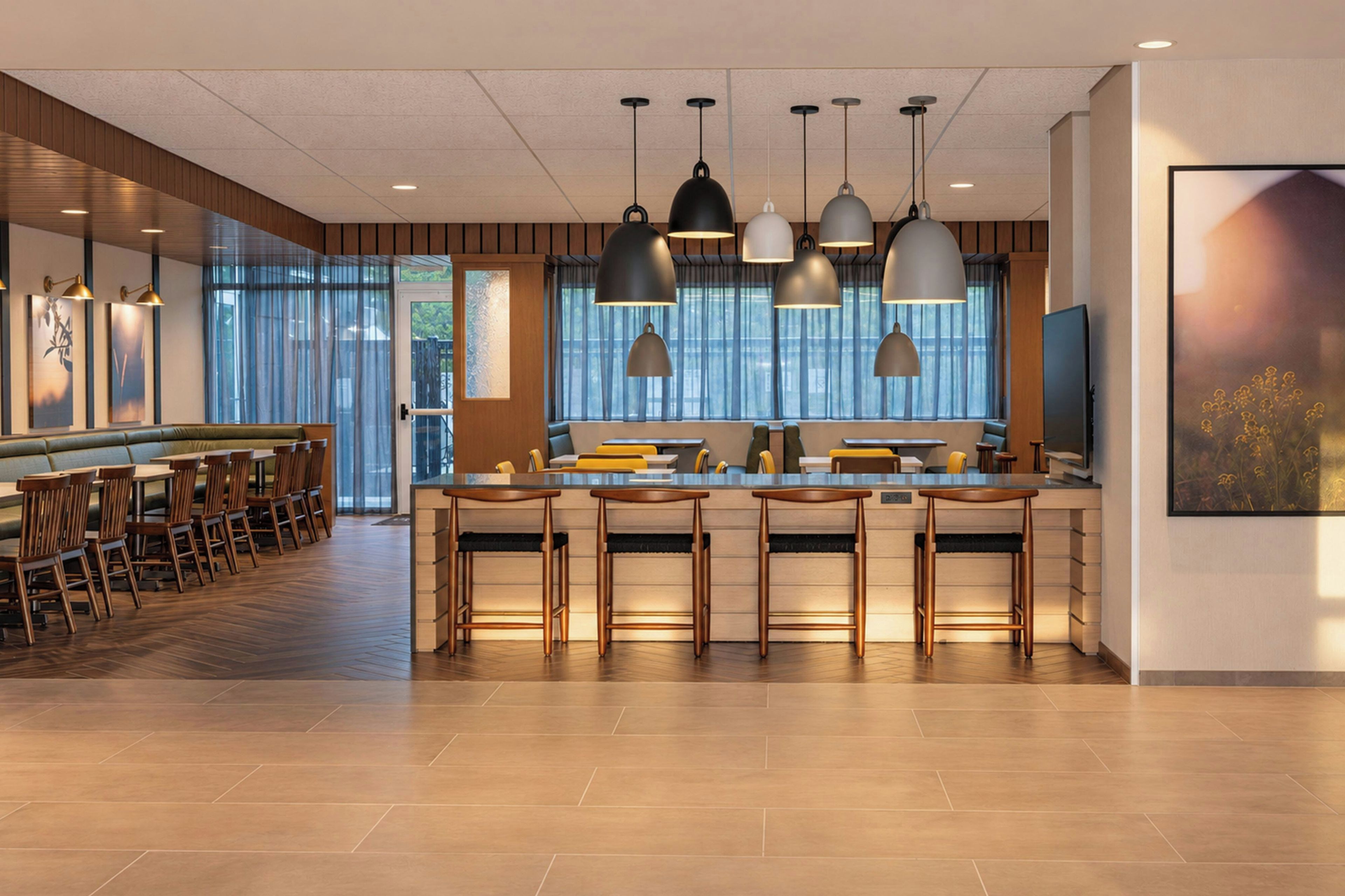 A modern kitchen with a central island, bar seating, and pendant lighting.