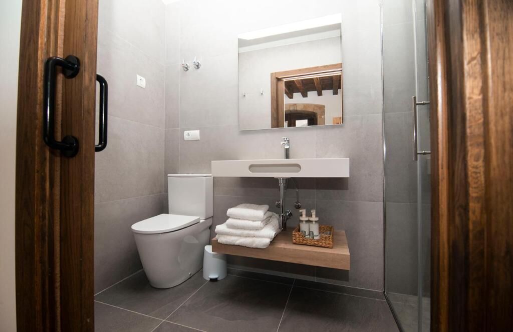 A modern bathroom with a toilet, sink, and shower.