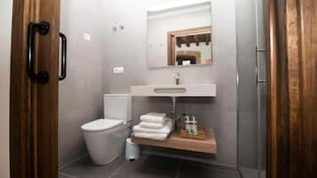 A modern bathroom with a toilet, sink, and shower.