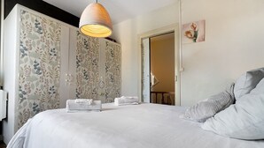 Une chambre à coucher avec un grand lit, une armoire et un luminaire suspendu.