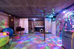 Habitació amb projecte de sostre, pilota d'exercici i cadira de massatge.