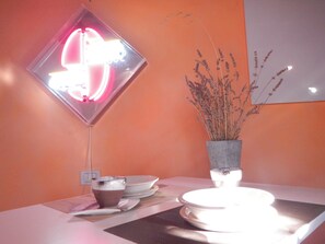 A table with a white plate, a bowl, and a cup. There is a vase with dried plants on the table. - Farmhouse with garden, parking and fitness area near Bologna center (Bologna, Emilia-Romagna)