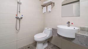 Un baño con inodoro, lavabo y ducha.