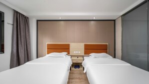 Habitación de hotel con dos camas, cabecero de madera, mesita de noche y puerta corredera.