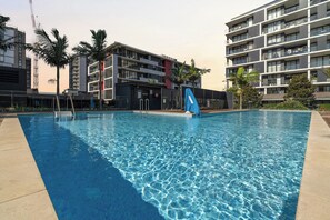 Ein Schwimmbad mit einem modernen Gebäude im Hintergrund.