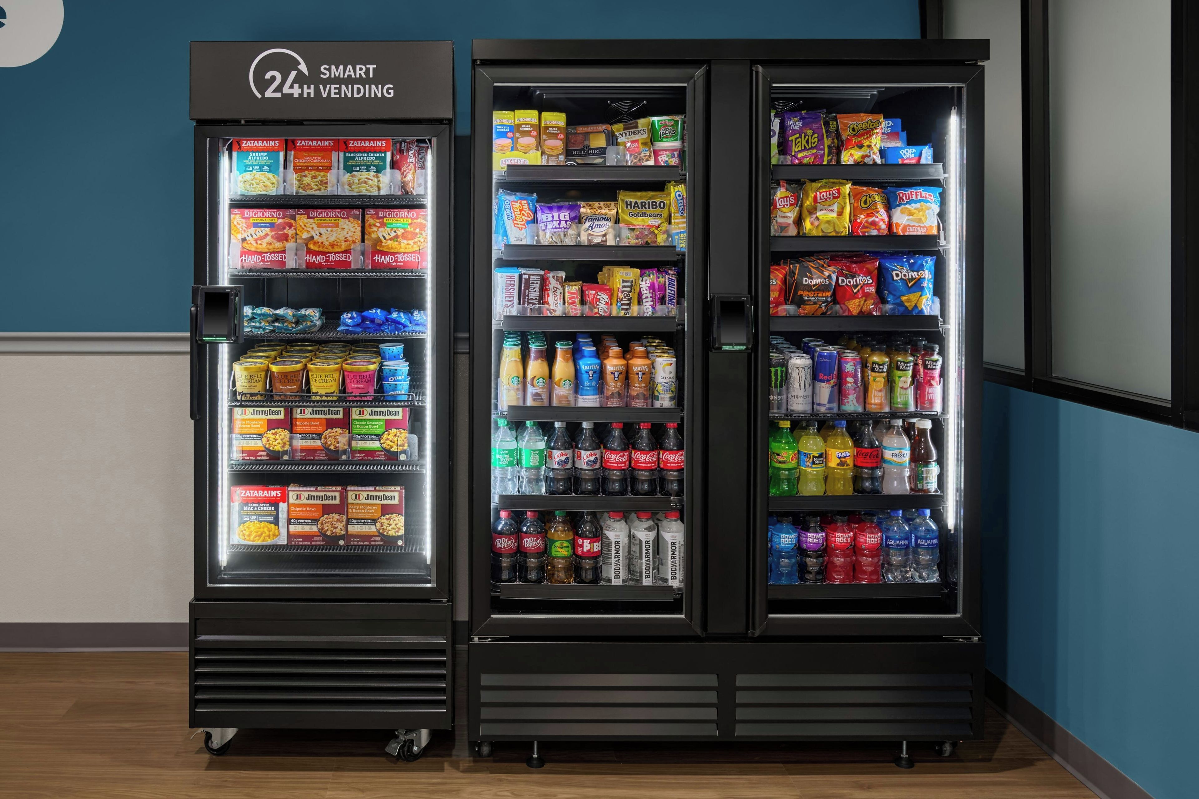 Three refrigerated vending machines with a variety of snacks, drinks, and ice cream.