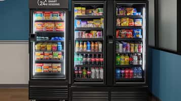 Three refrigerated vending machines with a variety of snacks, drinks, and ice cream.